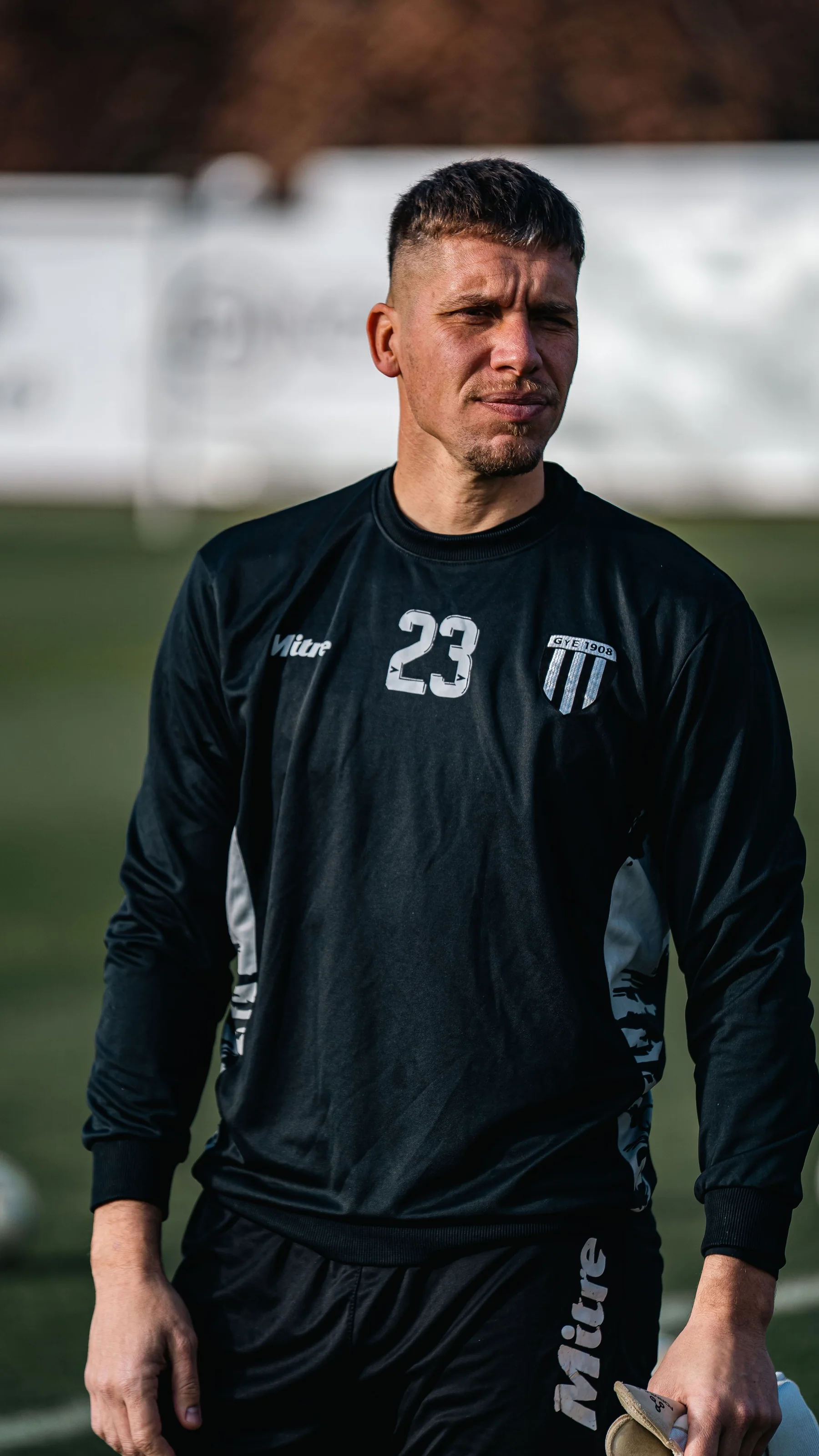 Erwachsener Fußballspieler in schwarzer Trainingskleidung auf dem Platz